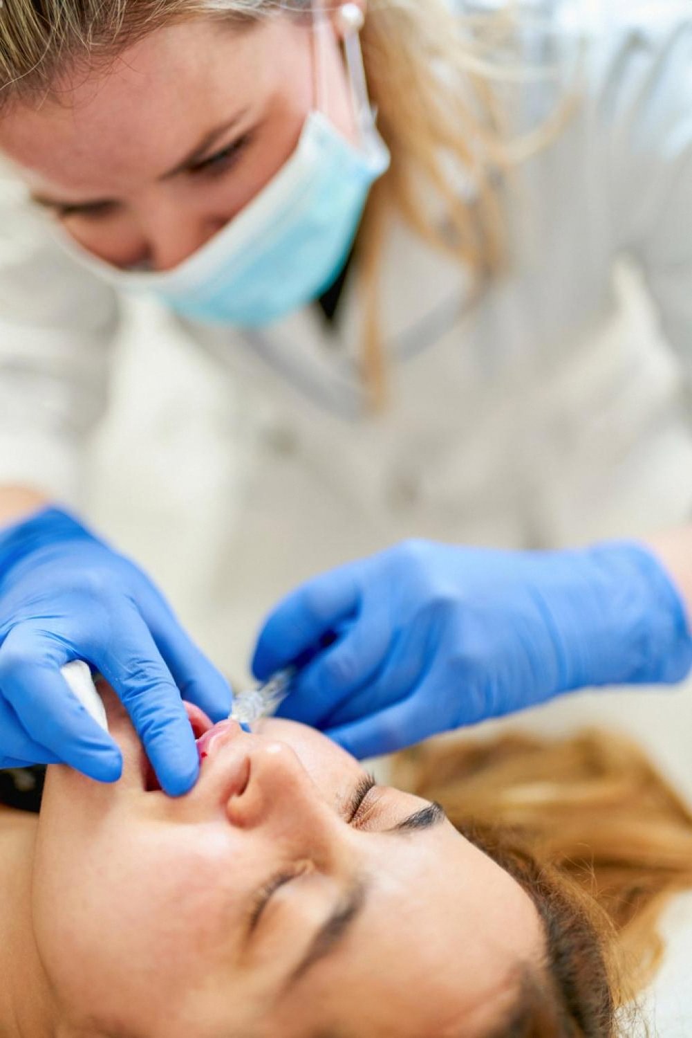 Cosmetologist performing a lip filler injection on a patient in a Dubai clinic